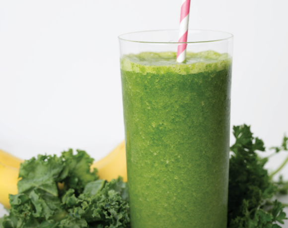 green smoothie in a glass with straw