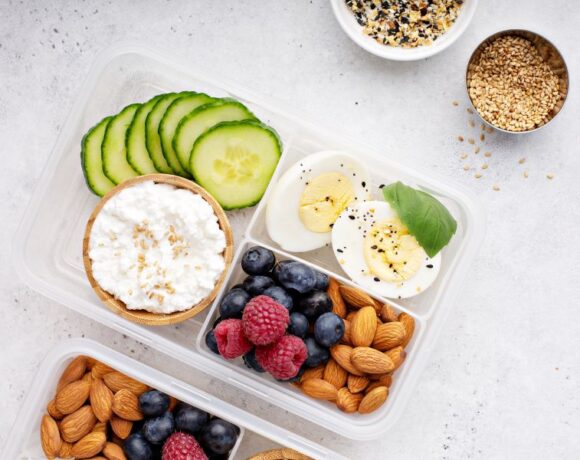 balanced snack with protein, fat and fiber displayed in a bento box style lunch box on a gray counter.